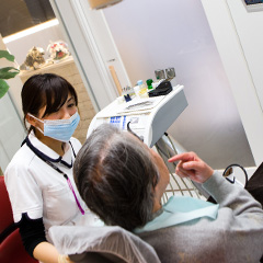歯科診察で女性に説明する女性歯科医師
